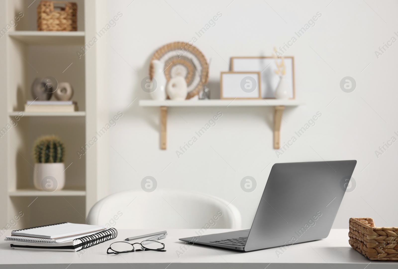 Photo of Home office. Laptop, glasses and stationery on white desk indoors. Space for text