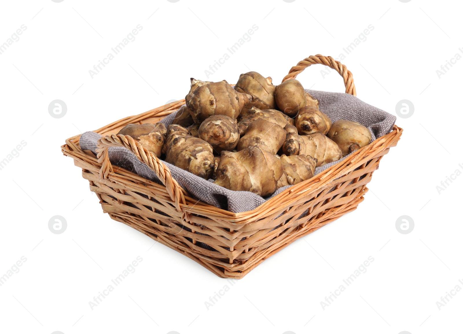 Photo of Wicker basket with many Jerusalem artichokes isolated on white