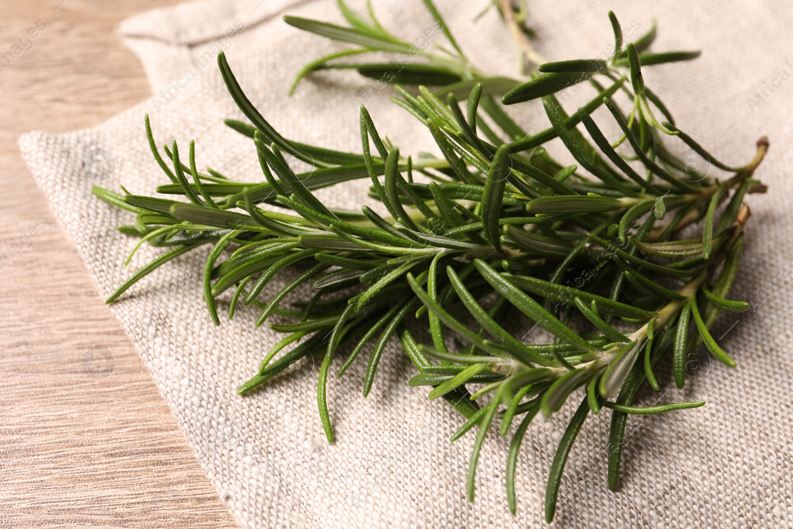 Photo of Fresh green rosemary on wooden table, closeup