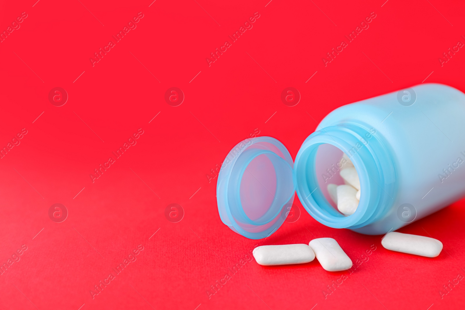 Photo of Jar with chewing gums on red background