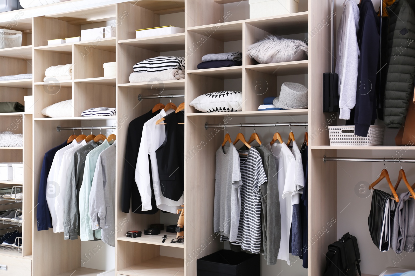 Photo of Stylish clothes, shoes and home stuff in large wardrobe closet