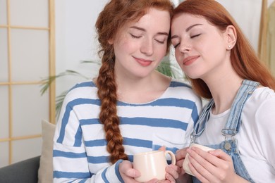 Photo of Portrait of beautiful young redhead sisters at home