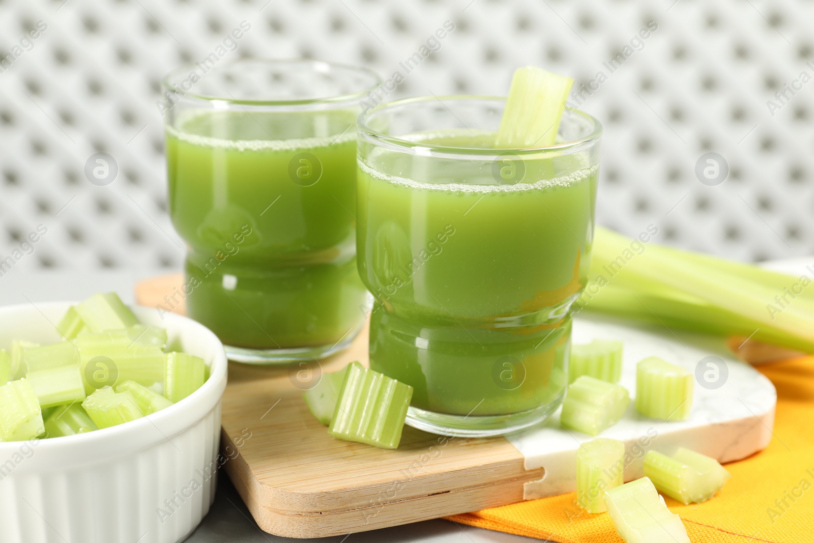 Photo of Celery juice and fresh vegetables on table, closeup