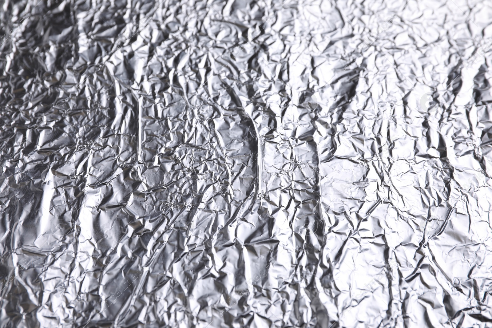 Photo of Crumpled silver foil as background, closeup view