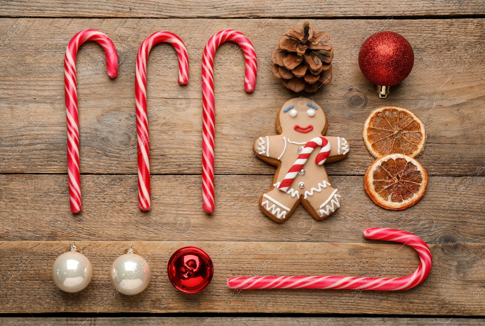 Photo of Flat lay composition with tasty candy canes and Christmas decor on wooden table