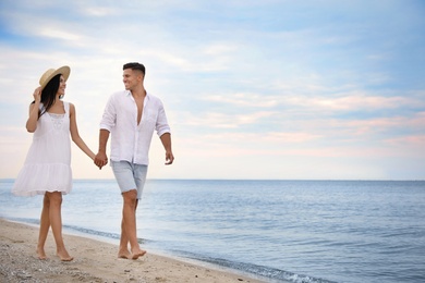 Photo of Lovely couple walking on beach. Space for text