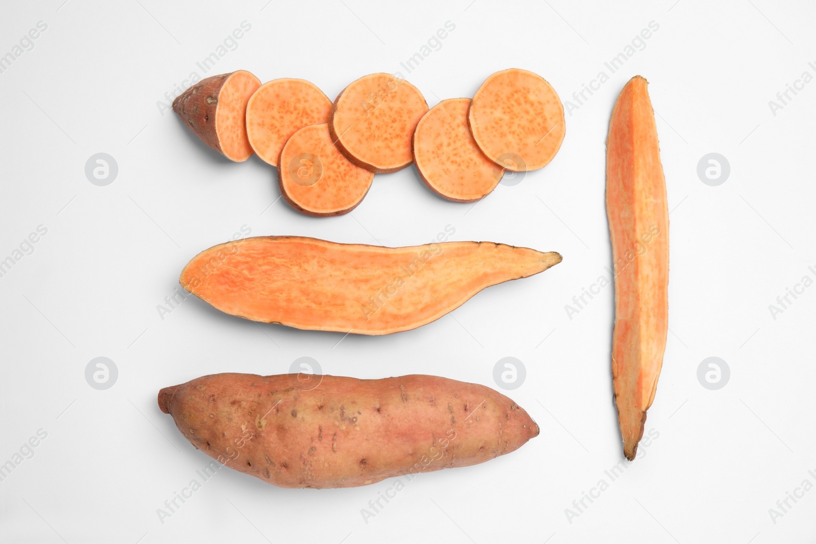 Photo of Cut and whole sweet potatoes on white background, top view