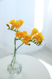 Photo of Beautiful yellow freesia flowers on table indoors