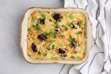 Photo of Tasty sausage casserole with green onions in baking dish on white table, top view