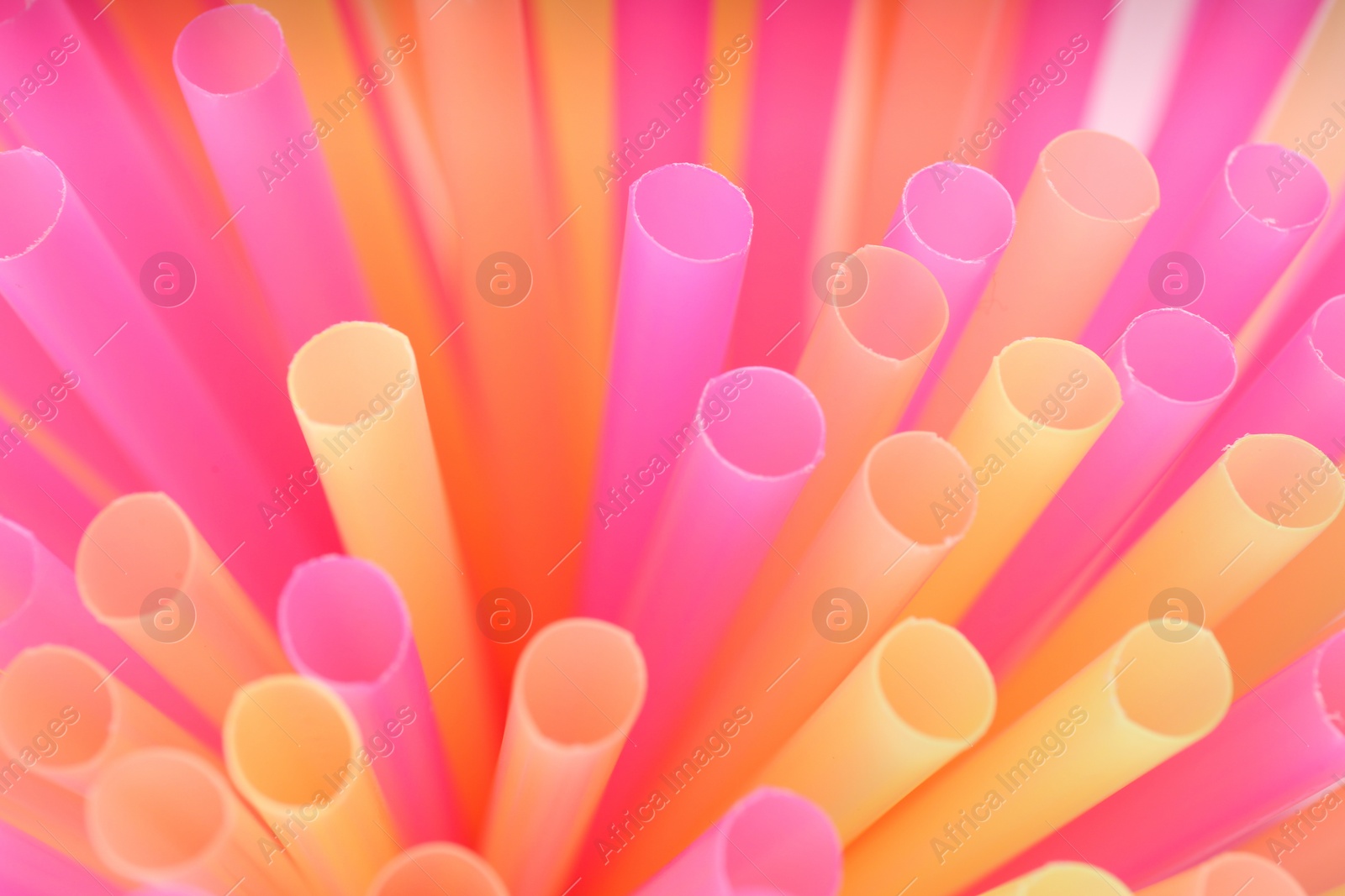 Photo of Heap of colorful plastic straws for drinks as background, closeup