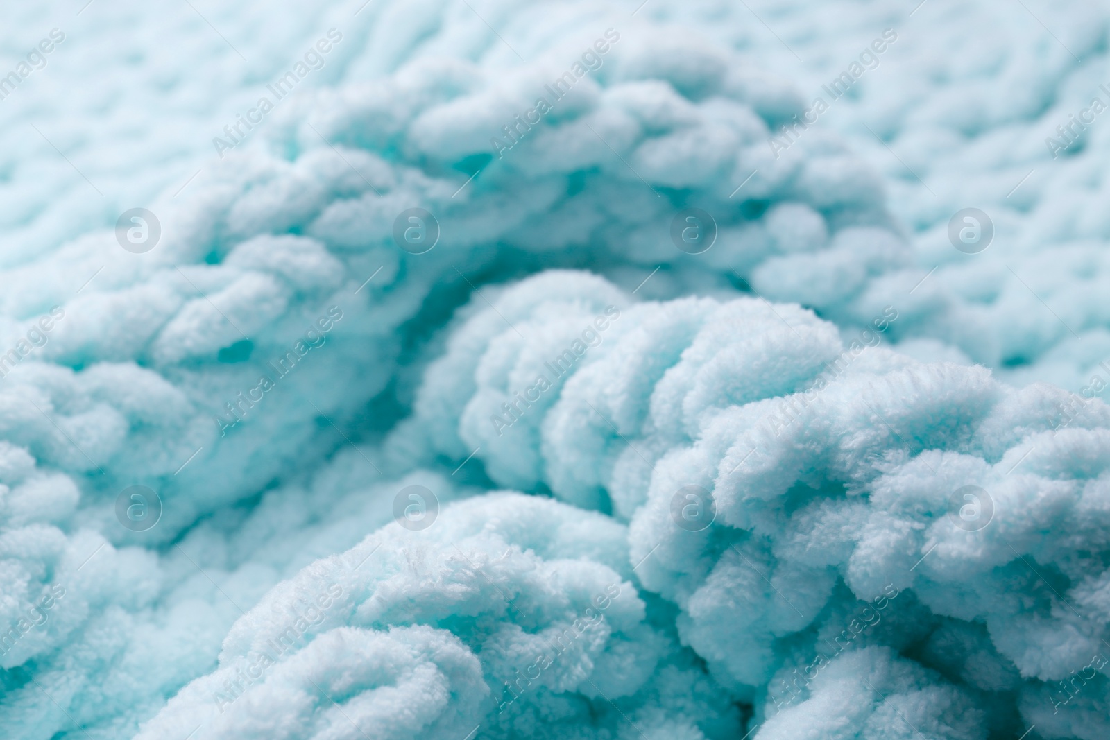 Photo of Soft light blue knitted fabric as background, closeup