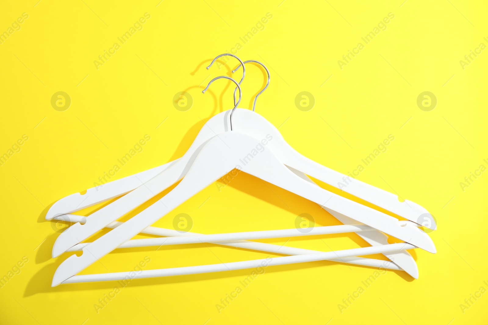 Photo of Flat lay composition with empty hangers on color background