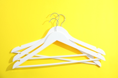 Photo of Flat lay composition with empty hangers on color background