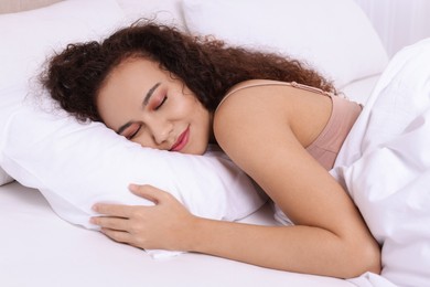 Beautiful African American woman sleeping in bed at home