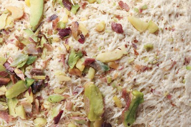 Photo of Tasty halva with pistachios as background, top view