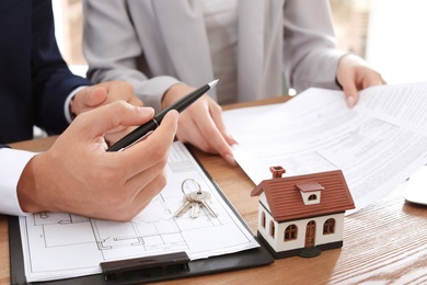 Photo of Real estate agent working with client in office, closeup