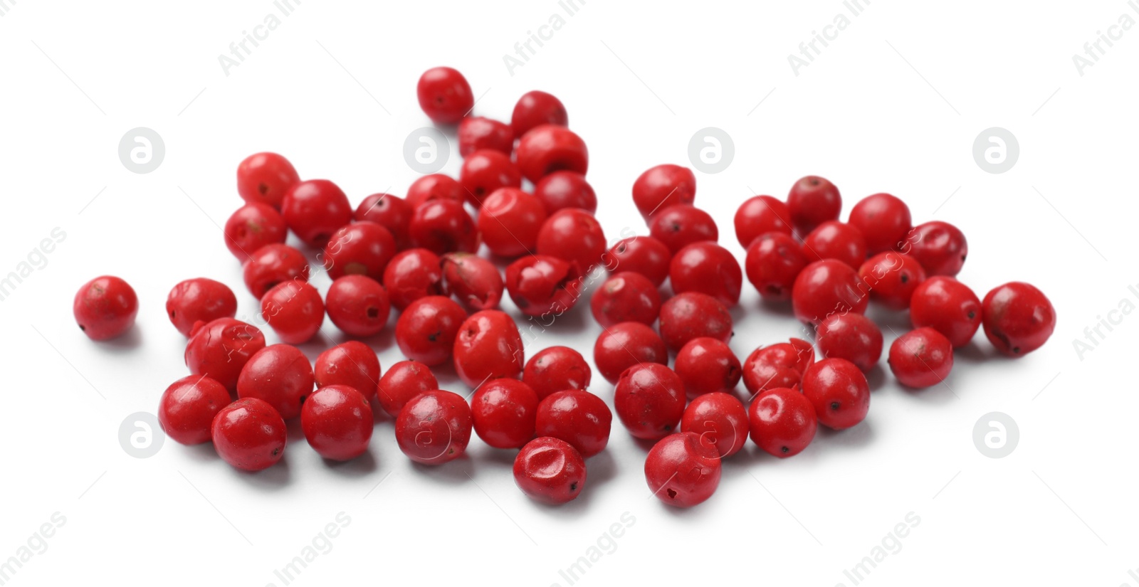 Photo of Aromatic spice. Many red peppercorns isolated on white