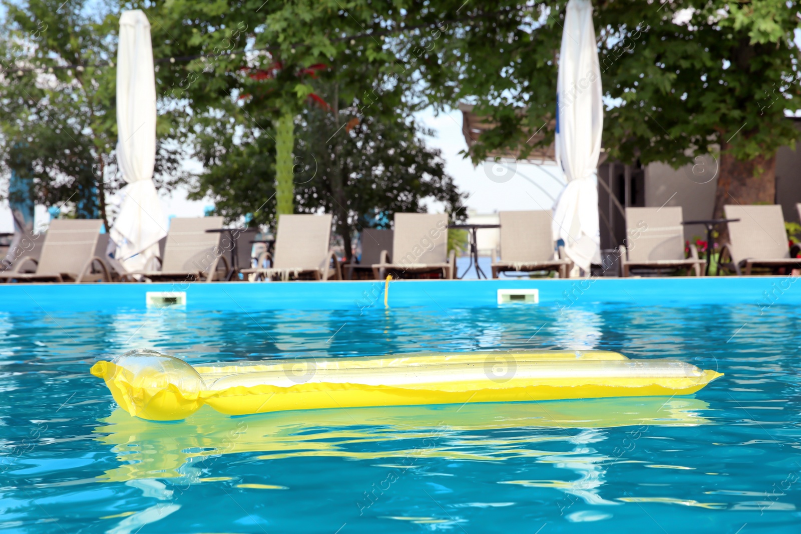 Photo of Inflatable mattress floating in swimming pool on sunny day