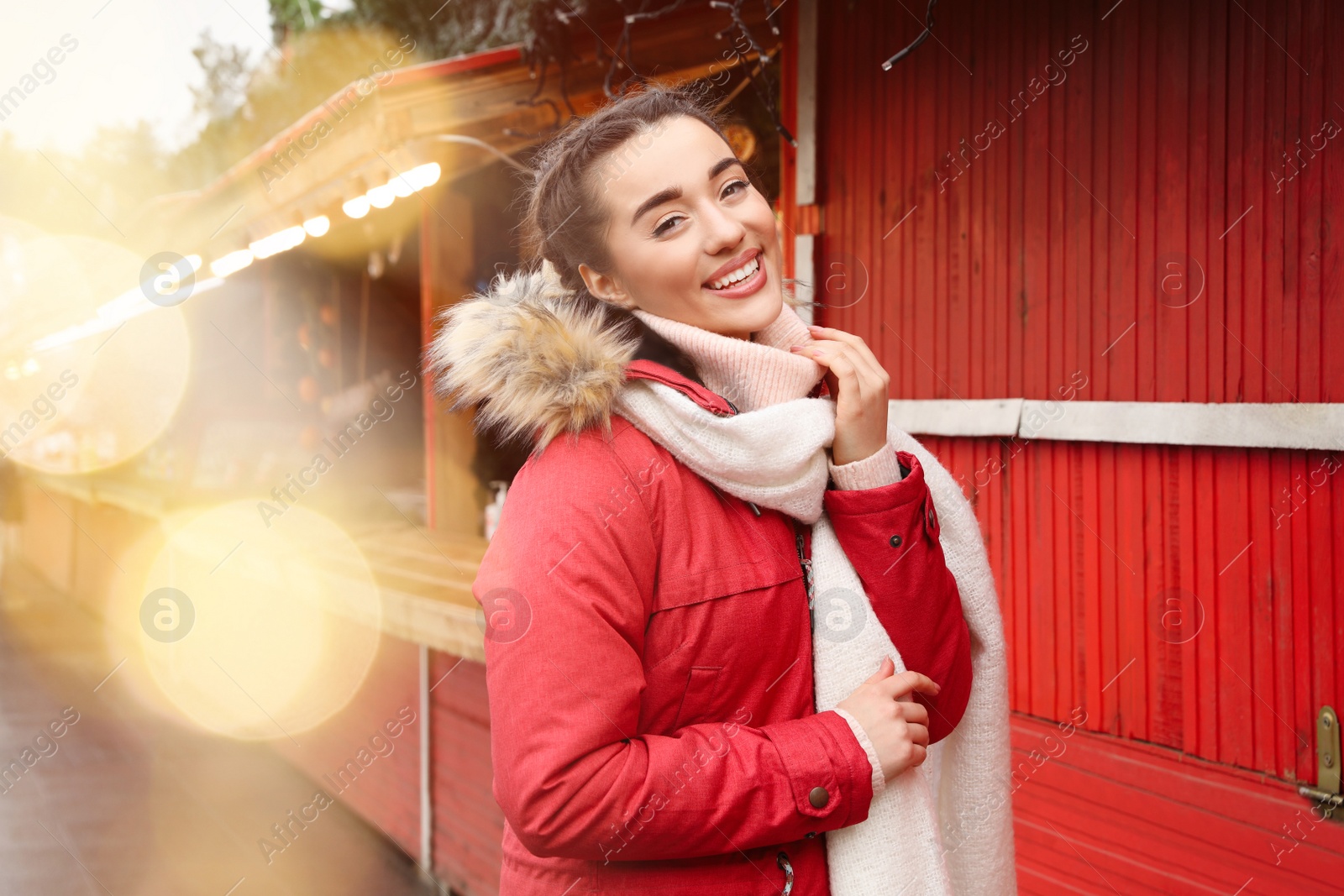 Photo of Young woman spending time at winter fair. Christmas celebration