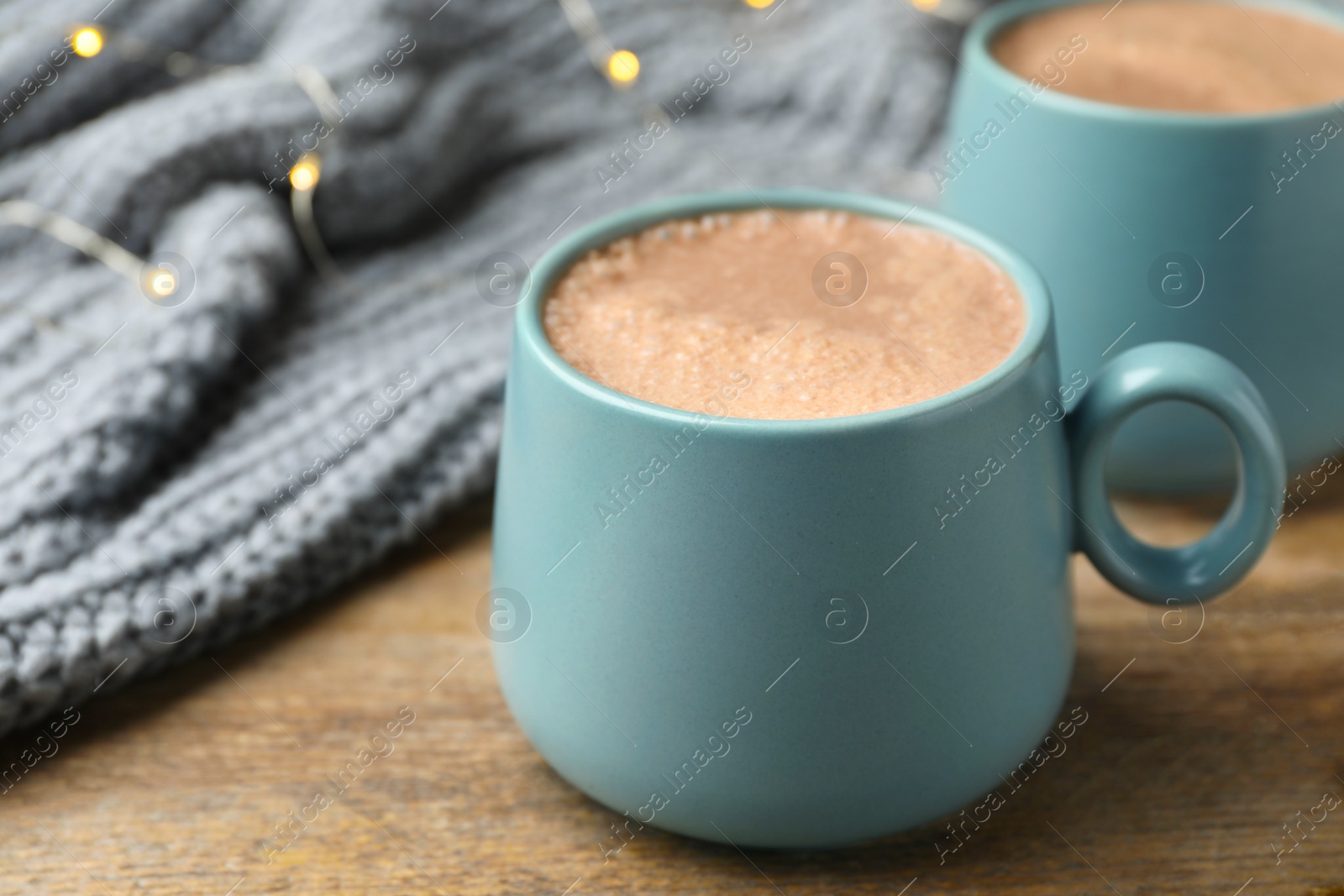 Photo of Cups of delicious hot cocoa on wooden table
