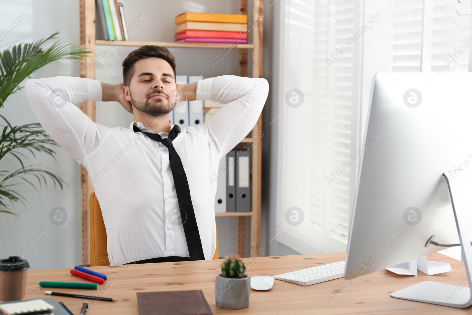 Photo of Lazy employee resting at table in office