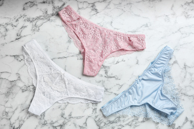 Photo of Sexy women's underwear on marble background, flat lay