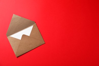 Photo of Letter envelope with card on red background, top view. Space for text