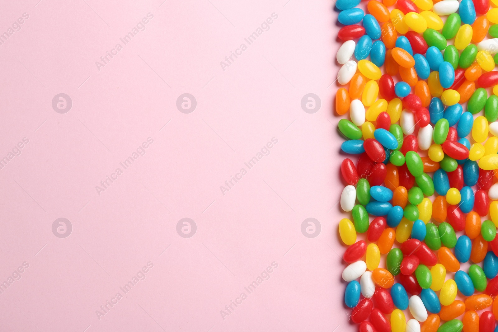 Photo of Flat lay composition with delicious jelly beans on light background. Space for text