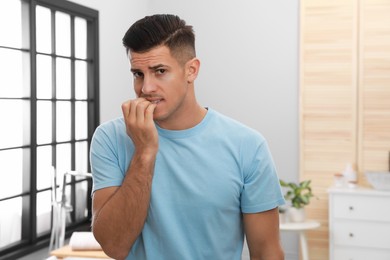 Photo of Man biting his nails indoors. Bad habit