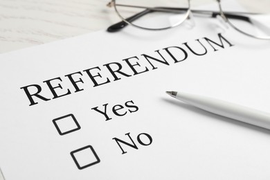 Photo of Referendum ballot with pen and glasses on table, closeup