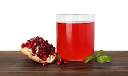 Photo of Refreshing pomegranate juice in glass, leaves and fruit on wooden table against white background