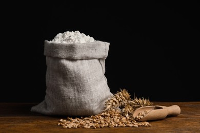 Wheat flour in sack bag, spikes and grains on wooden table