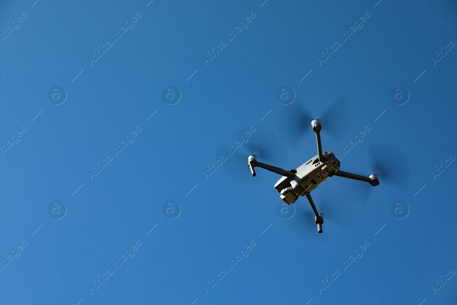 Photo of Modern drone with camera flying in sky on sunny day