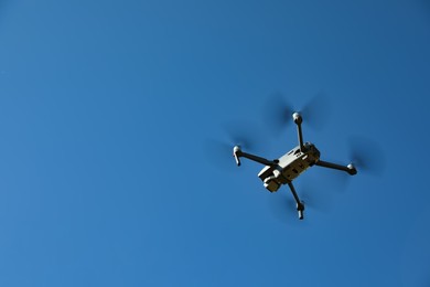 Modern drone with camera flying in sky on sunny day