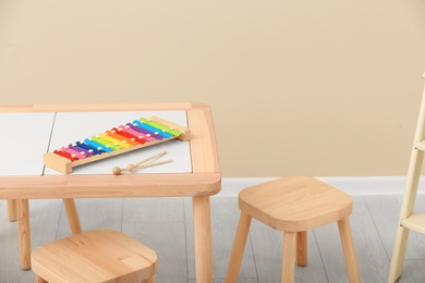 Photo of Stylish child's room interior with rainbow glockenspiel on wooden table