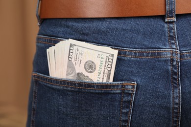 Photo of Dollar banknotes in pocket of jeans, closeup