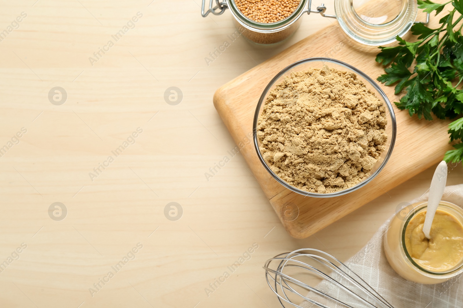 Photo of Flat lay composition with aromatic mustard powder and parsley on wooden table. Space for text