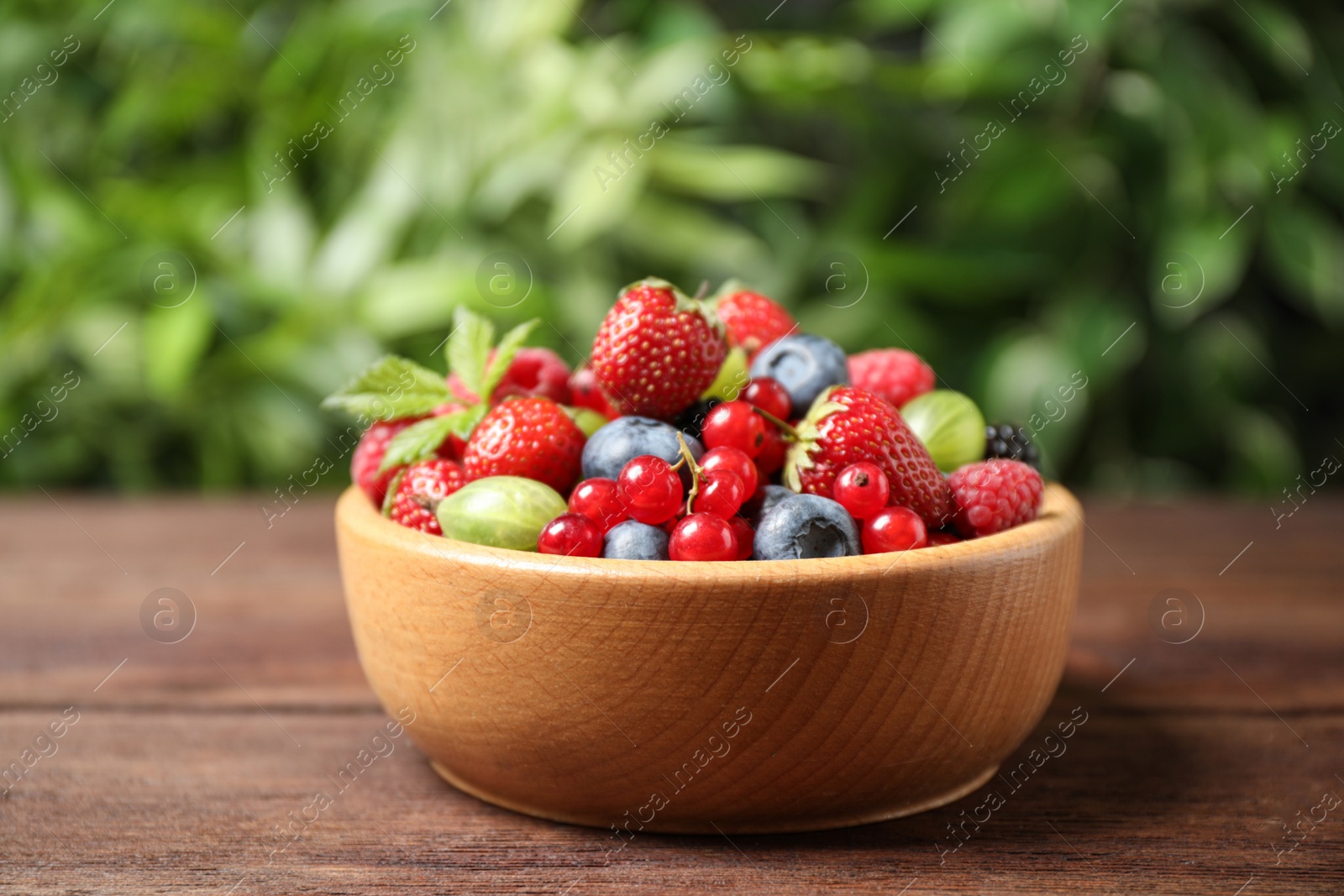 Photo of Mix of ripe berries on wooden table