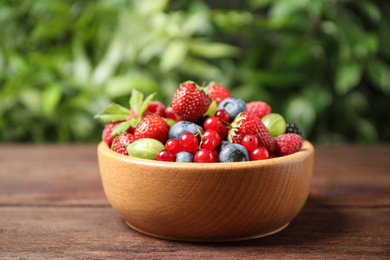 Mix of ripe berries on wooden table