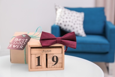 Calendar with date and gift box on table. Father's day celebration