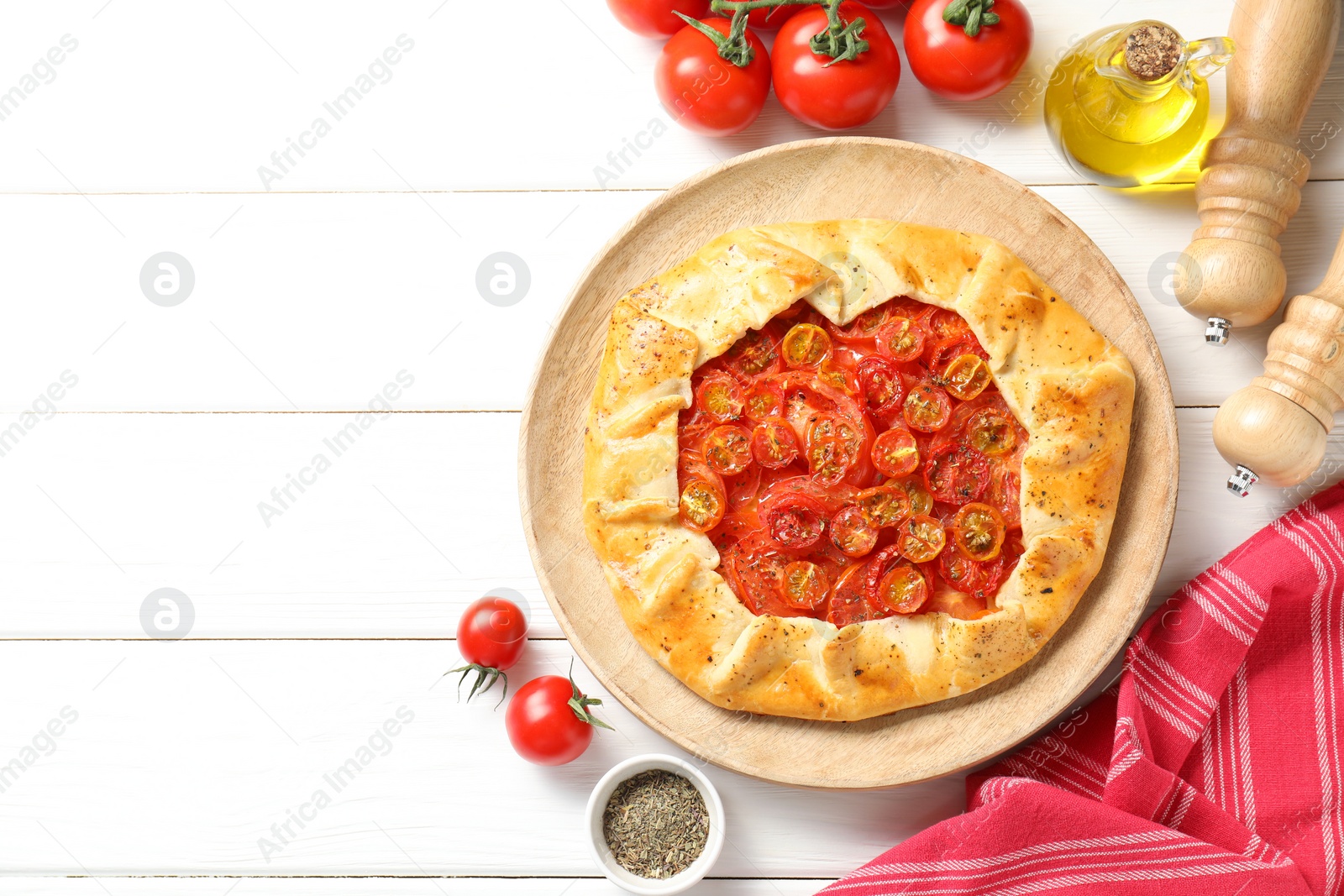 Photo of Flat lay composition with tasty tomato galette (Caprese galette) on white wooden table. Space for text