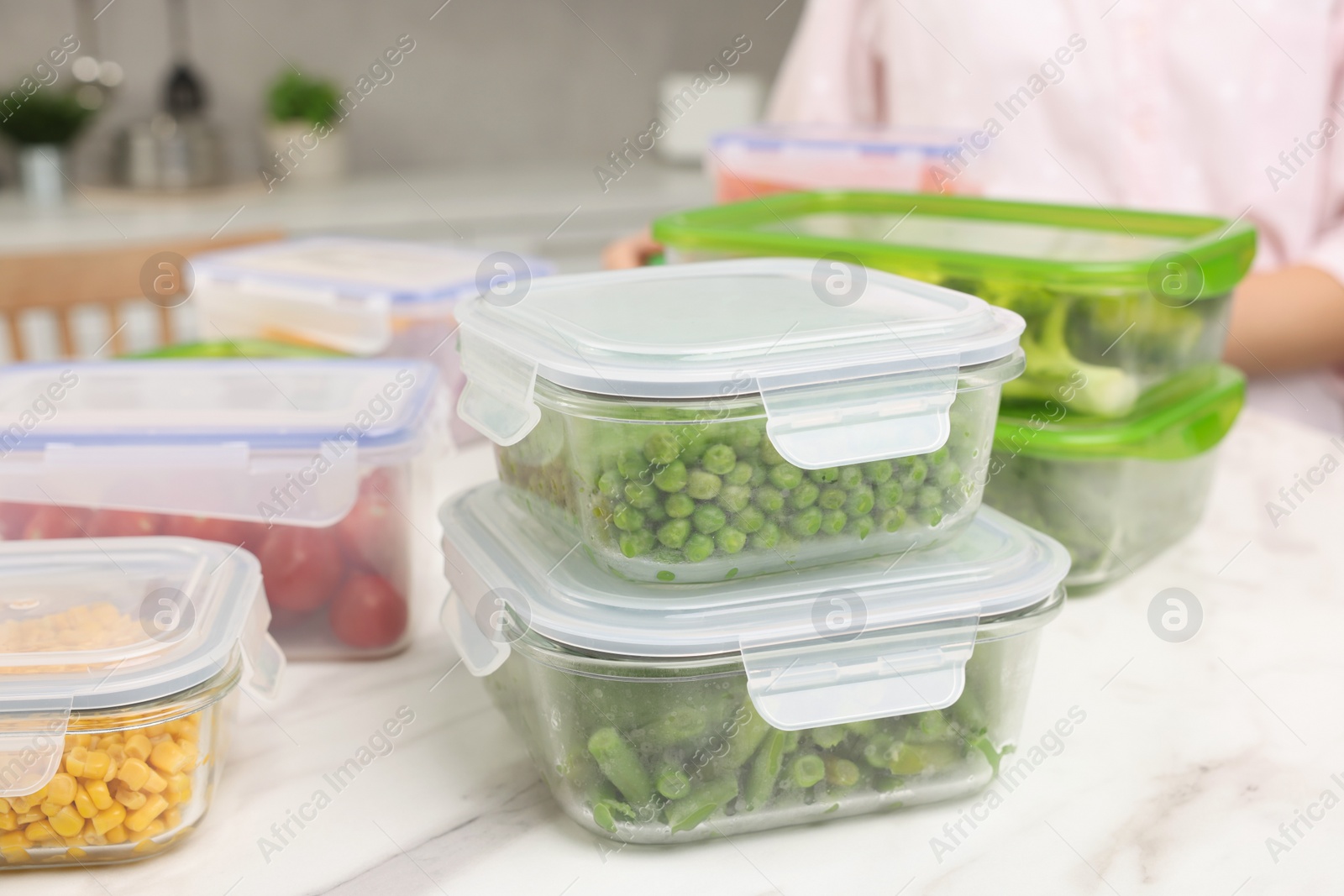 Photo of Containers with different fresh products on white marble table in kitchen, selective focus. Food storage