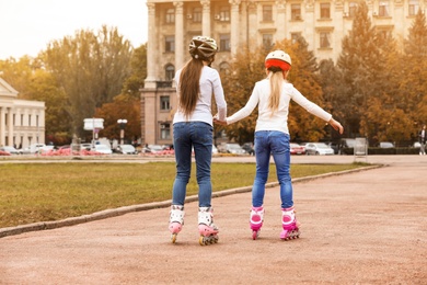 Photo of Cute children roller skating on city street