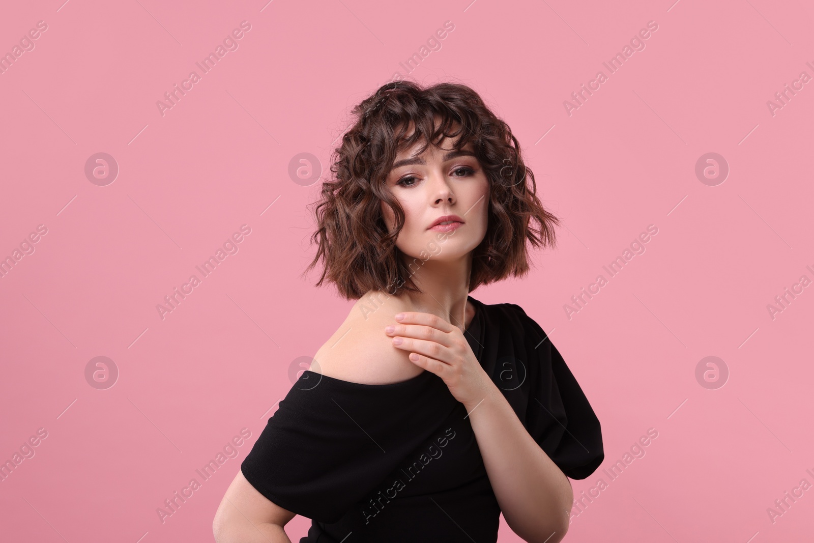 Photo of Portrait of beautiful young woman with wavy hairstyle on pink background