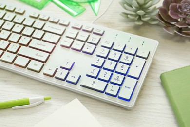 Photo of Modern RGB keyboard on white wooden table