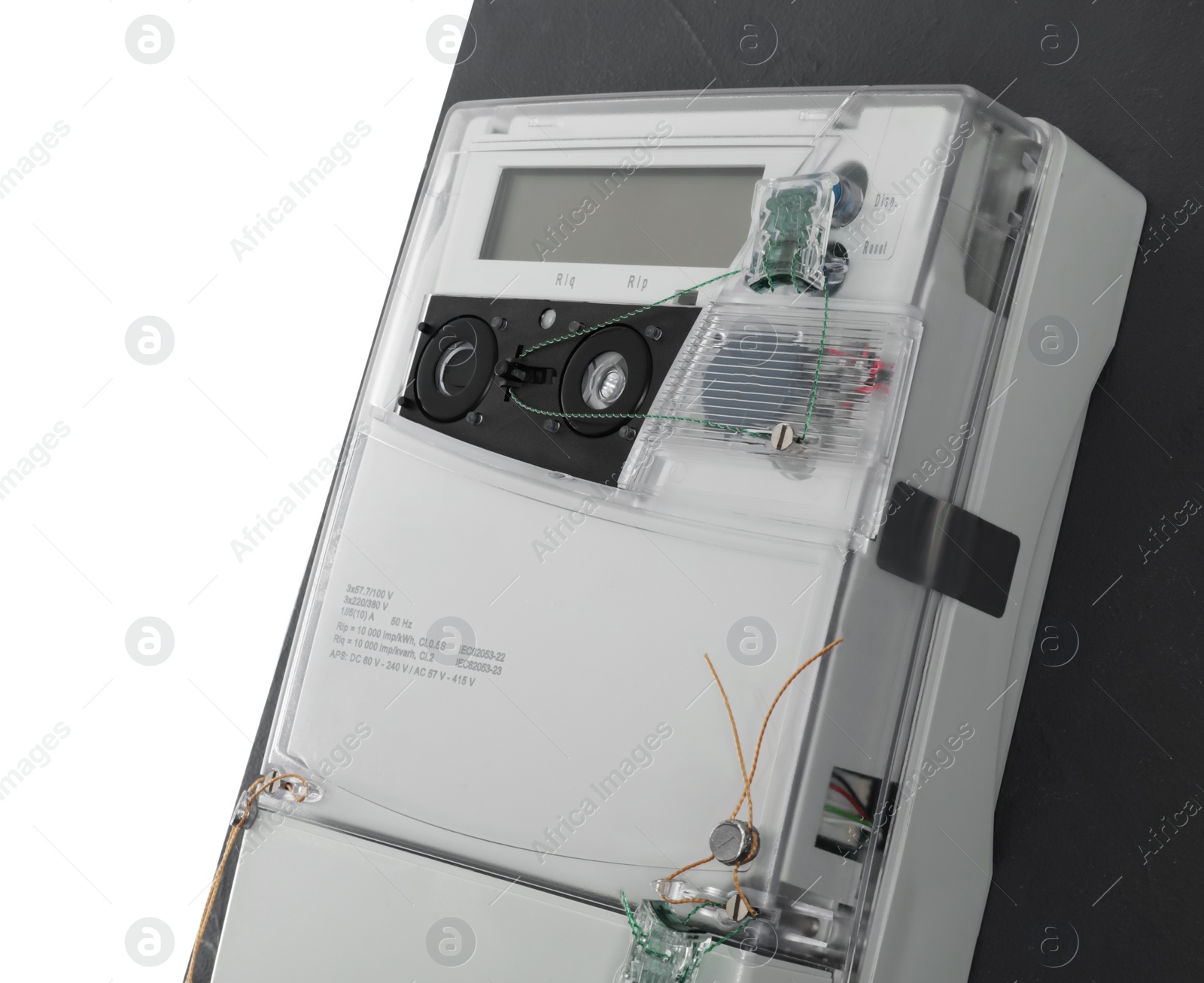 Photo of Electricity meter on grey wall against white background, closeup. Space for text