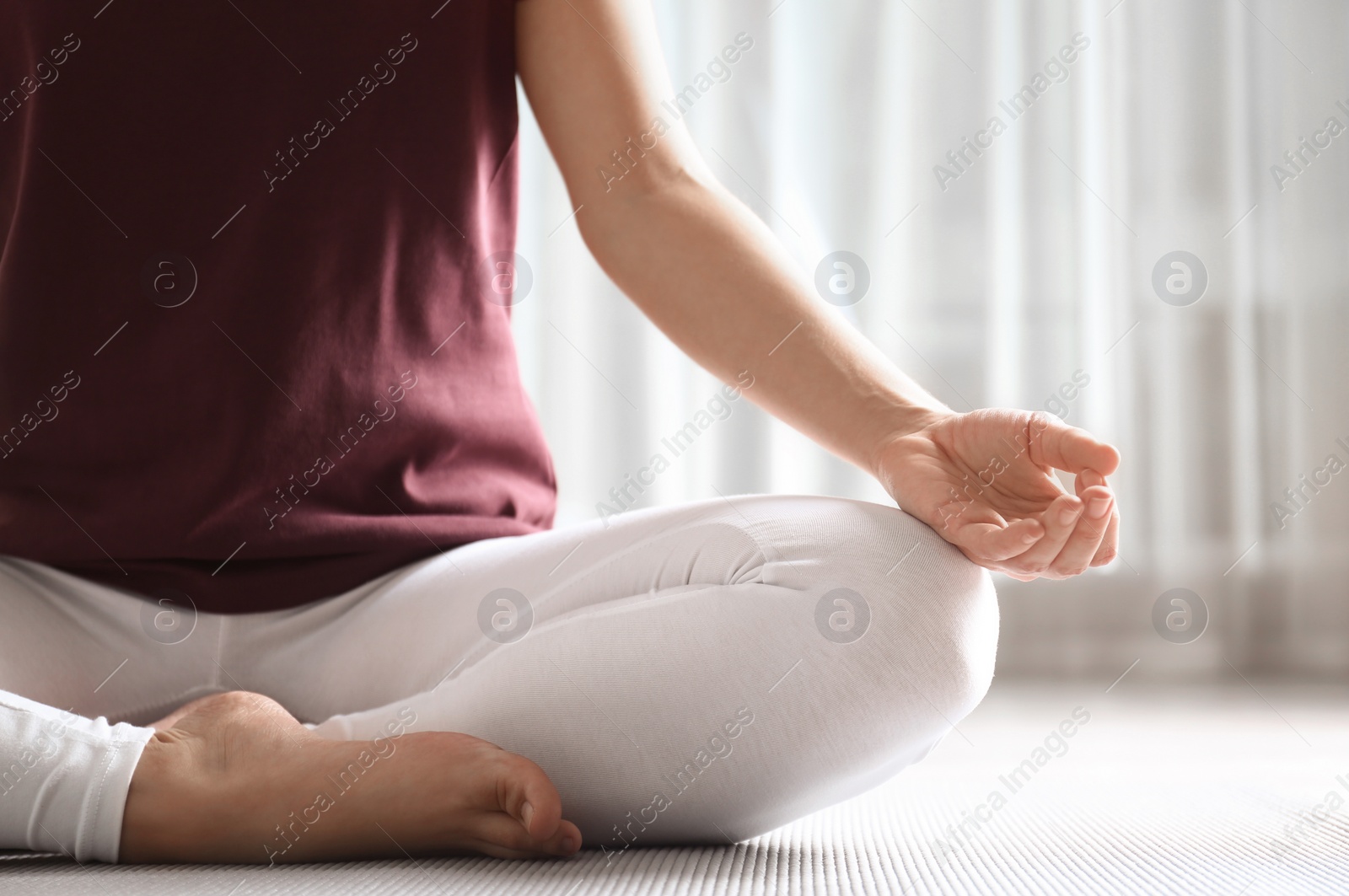 Photo of Woman practicing yoga on floor indoors, closeup