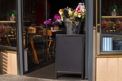 Photo of Entrance of cafe with potted flowers outdoors