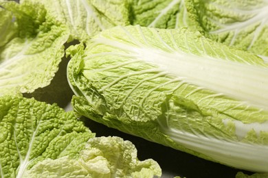 Fresh ripe Chinese cabbage and green leaves on table, closeup