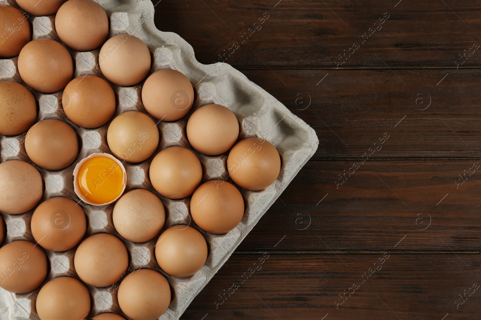 Photo of Raw chicken eggs on wooden table, top view